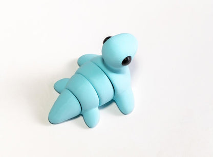 Snuggliez Baby Nessi“  Bewegliches Mini-Nessiewesen & kleiner ADHS-Helfer